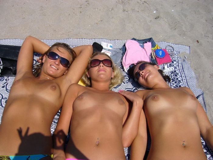 Голая девушка без стеснения загорает на пляже - секс порно фото